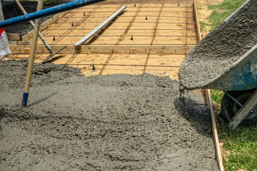 A Person Is Pouring Concrete Into A Wheelbarrow — S & K Gallaway Concreting In West Mackay, QLD