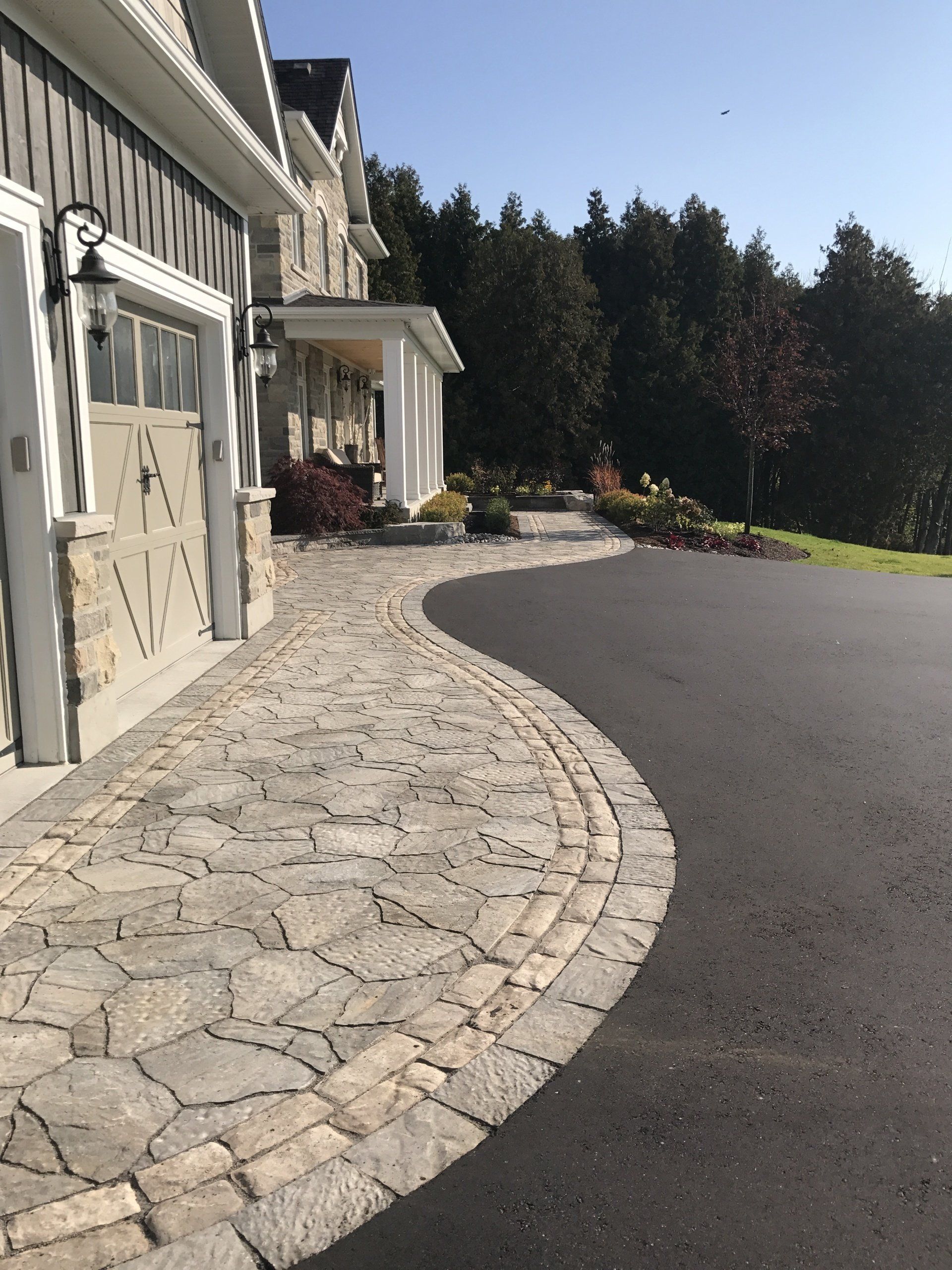 A driveway with a stone walkway leading to a house