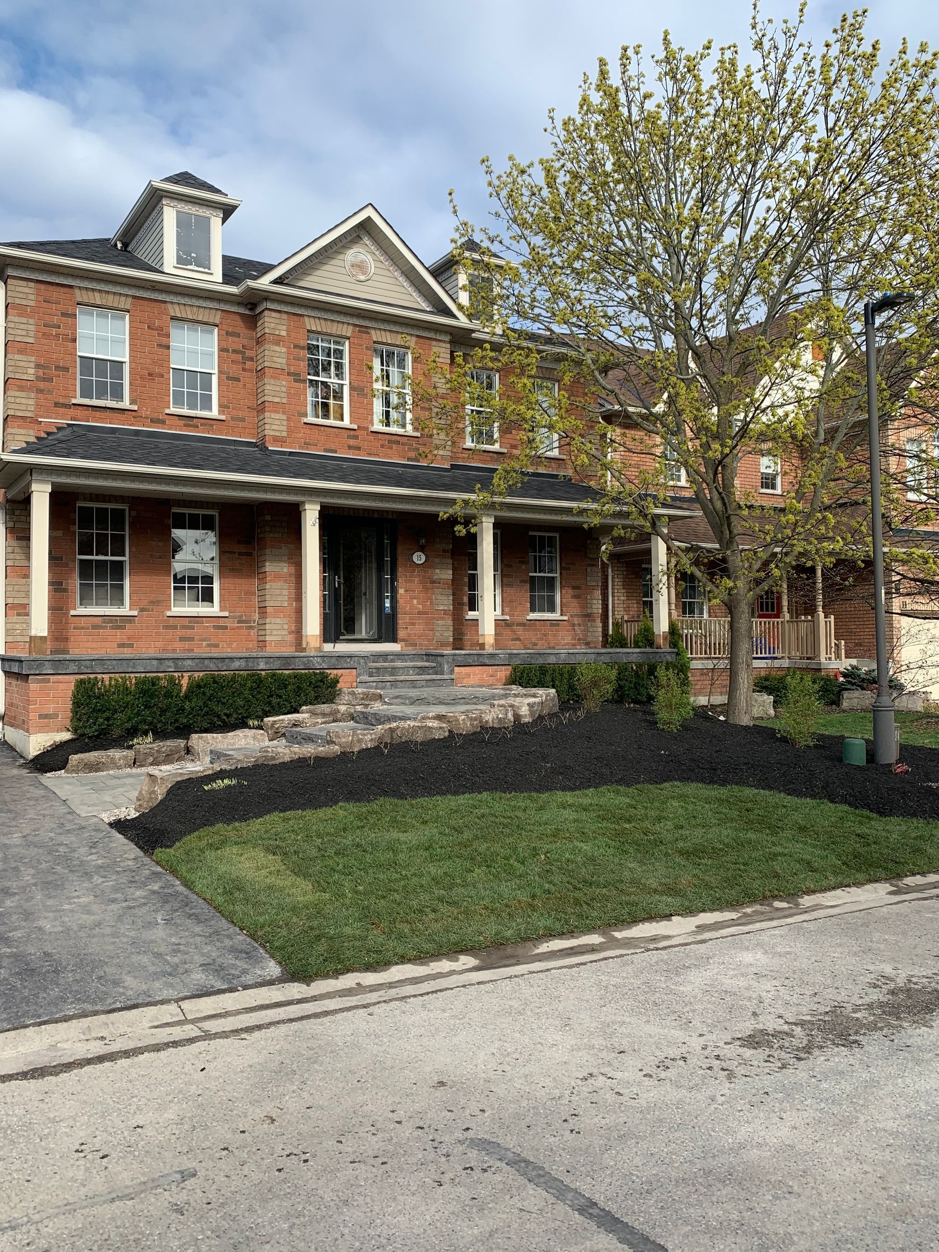 A large brick house with a tree in front of it