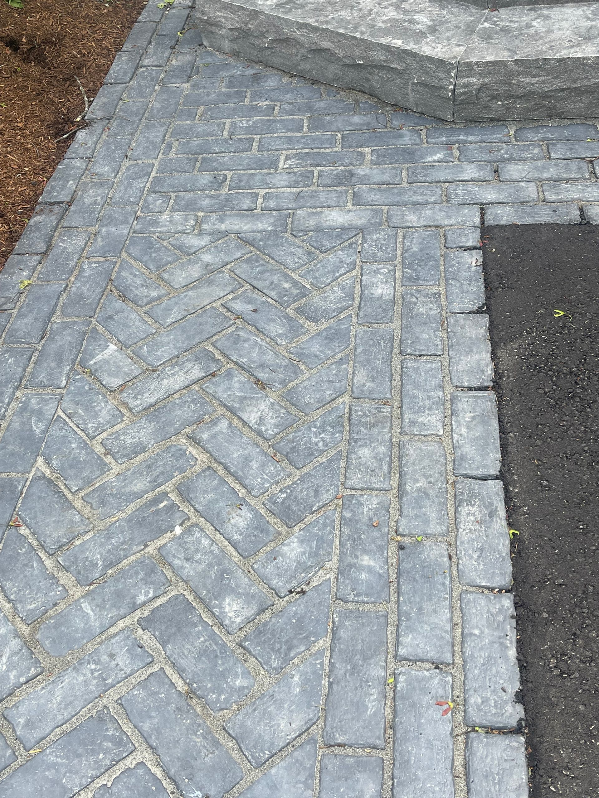 A walkway made of bricks in a herringbone pattern