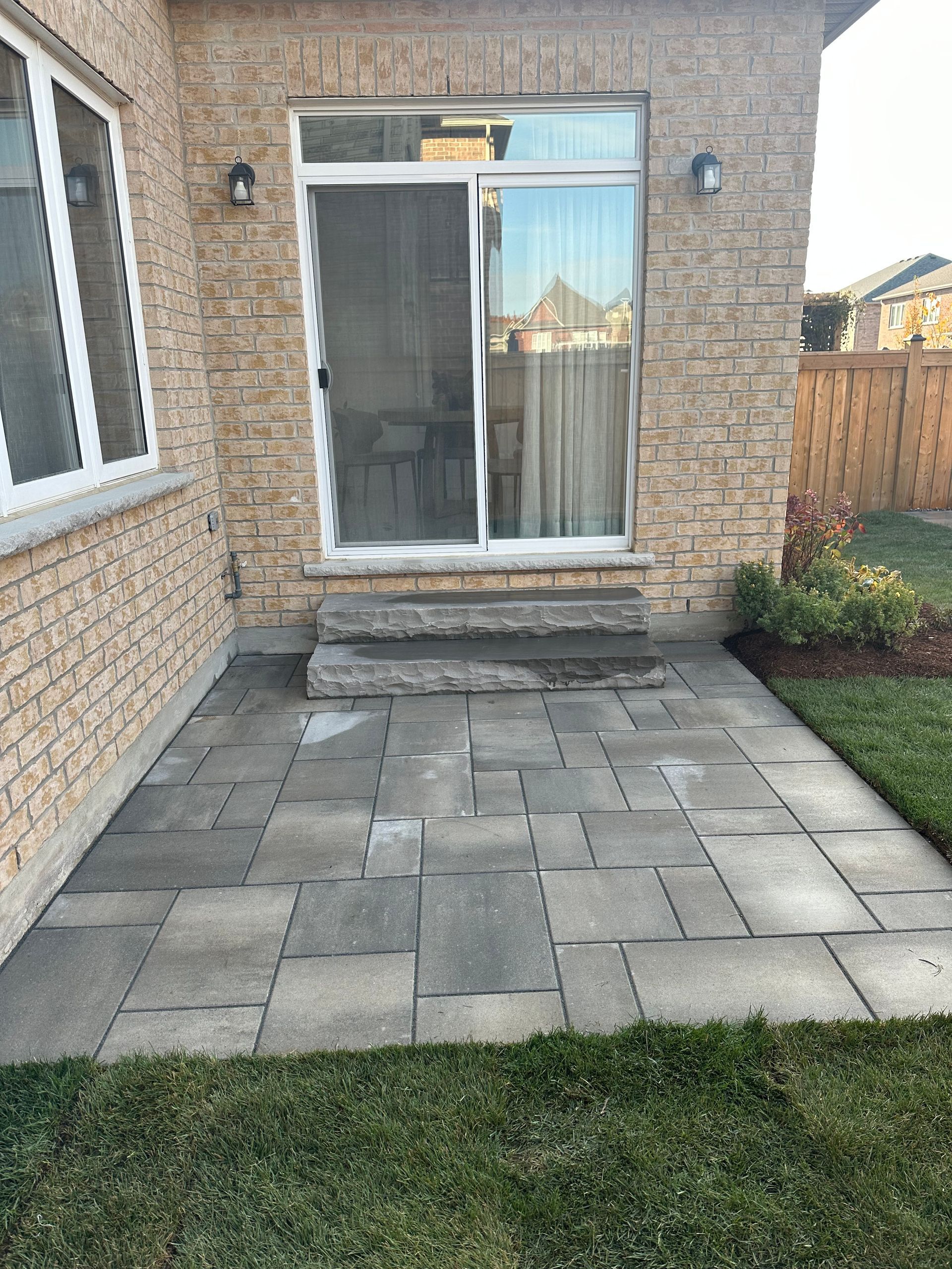 A brick house with a patio and a sliding glass door.