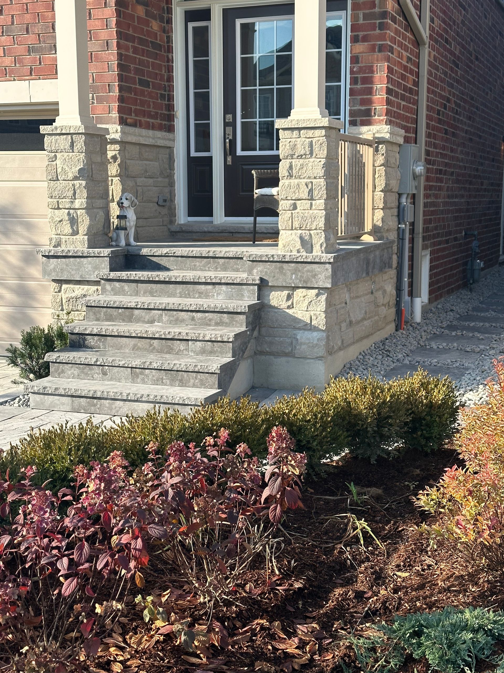 A brick house with stairs leading up to the front door