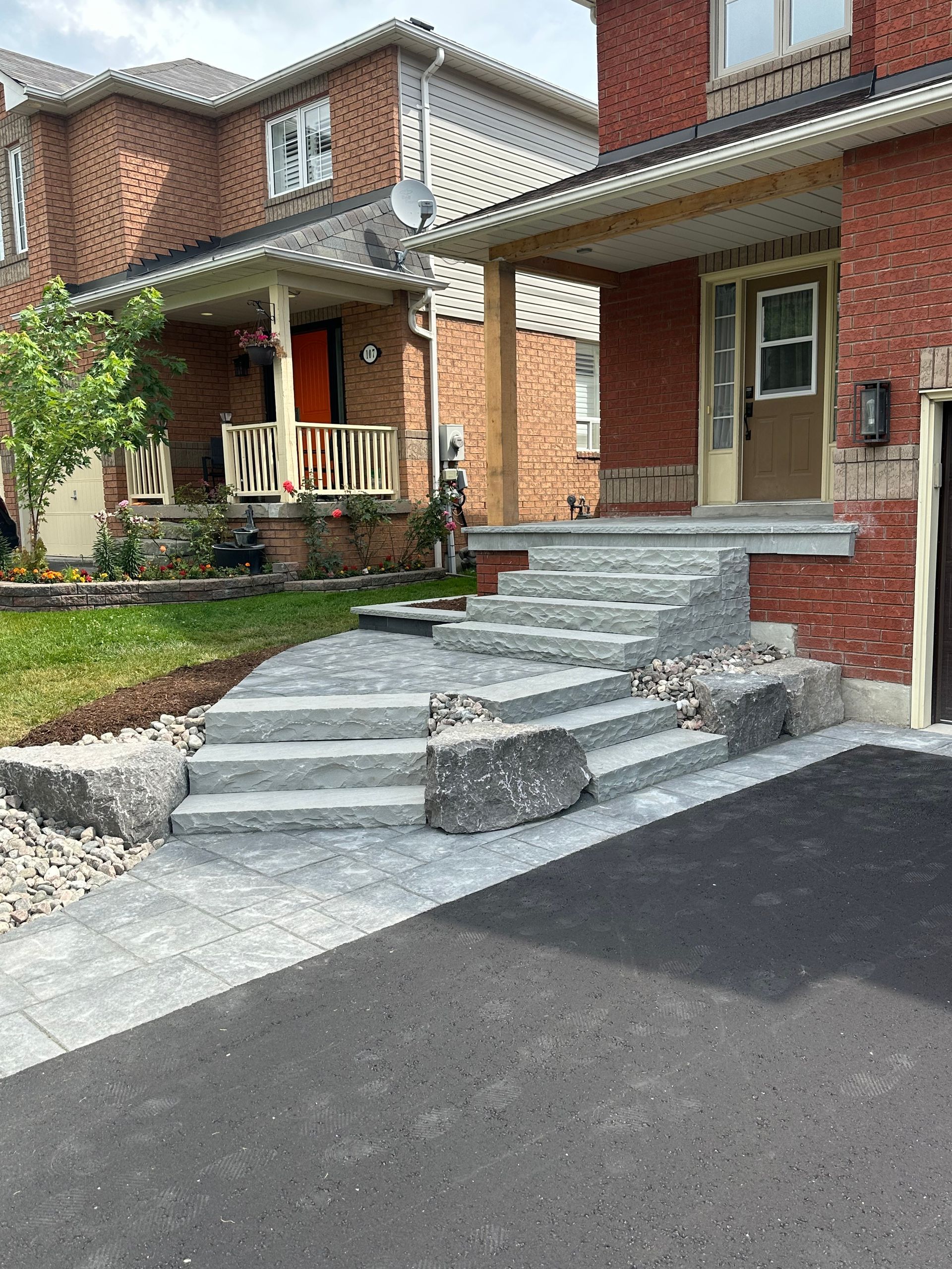 A brick house with stairs leading up to the front door