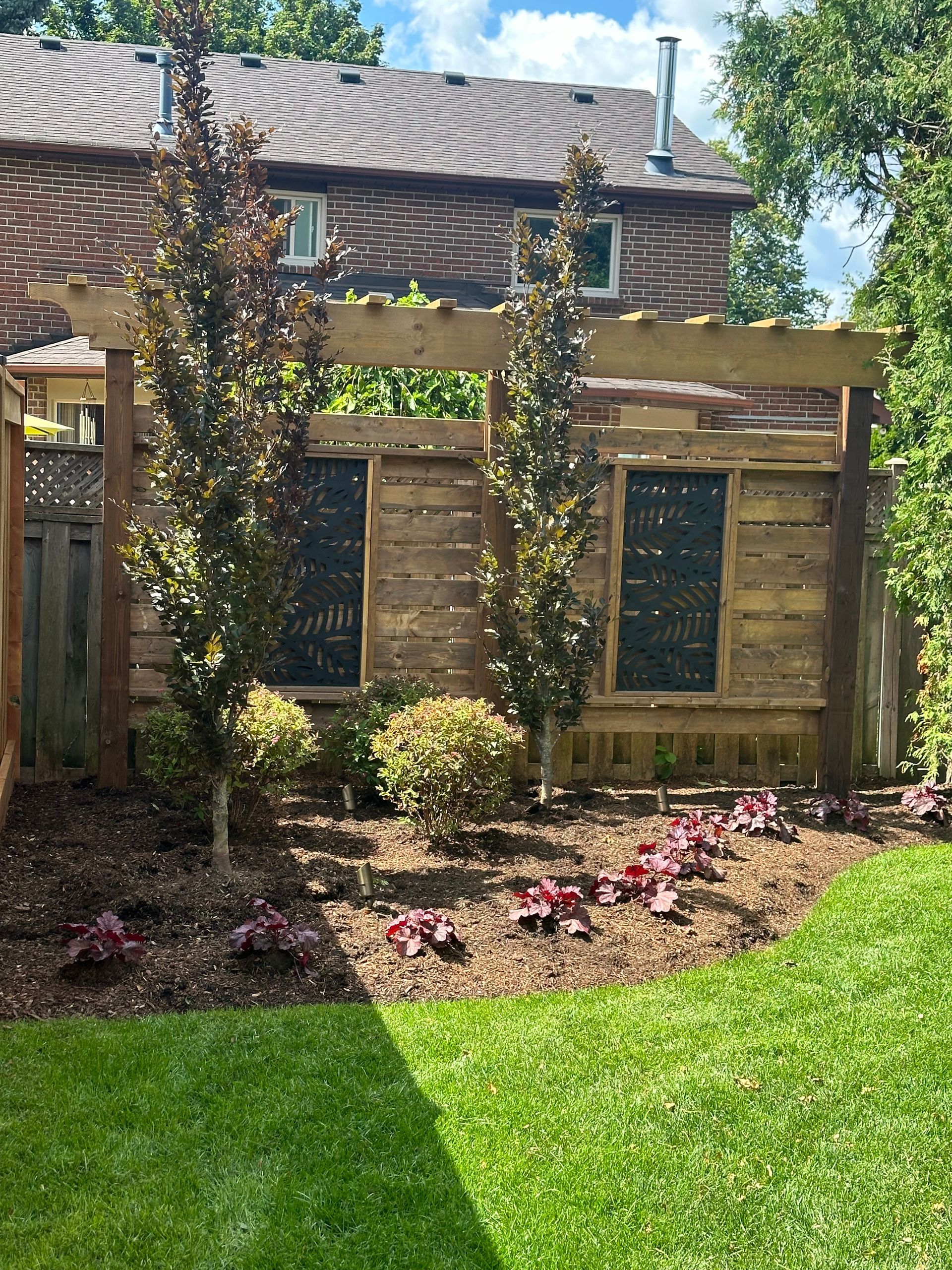 There is a wooden pergola in the backyard of a house.