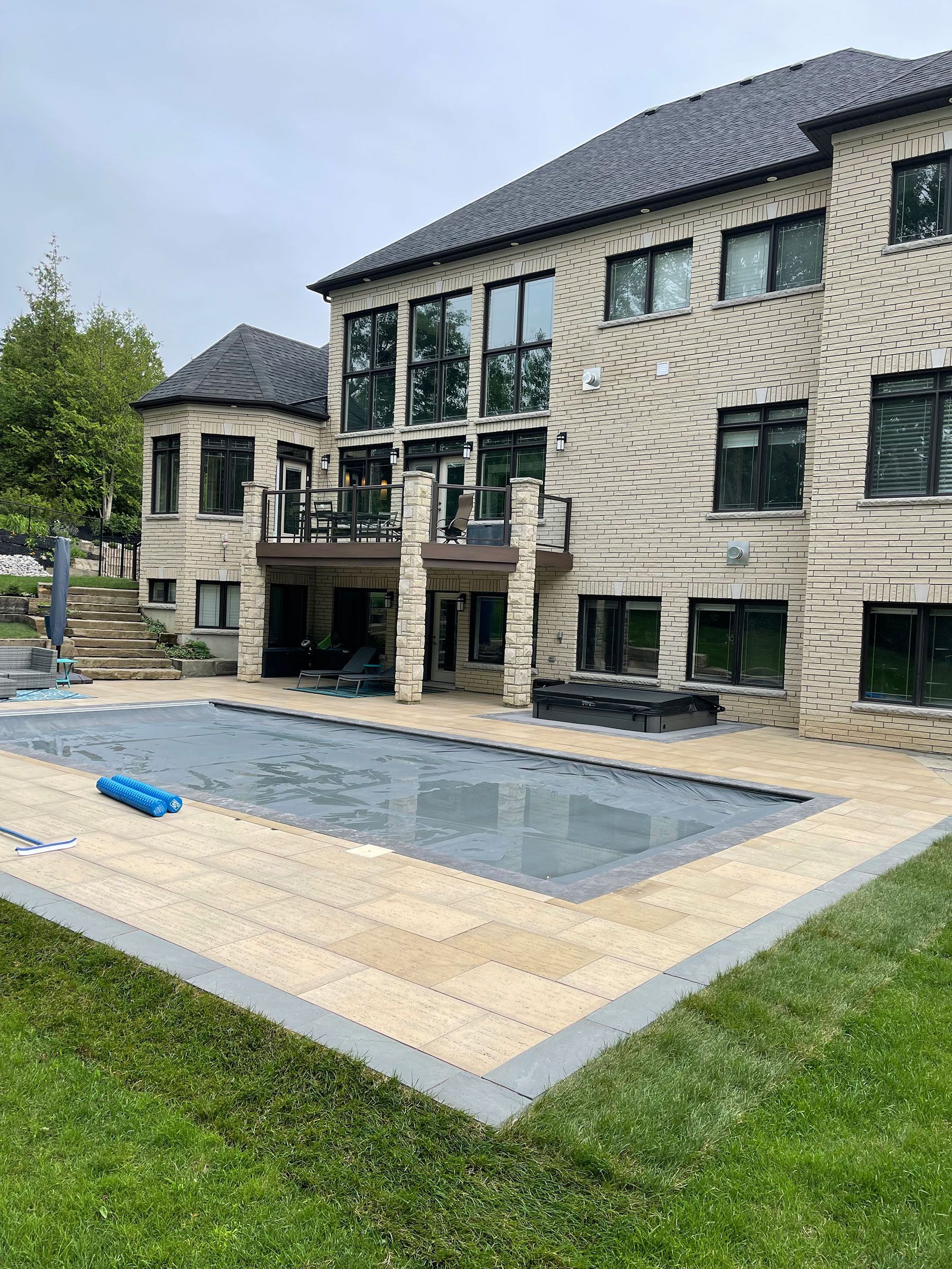 A large house with a large swimming pool in front of it.