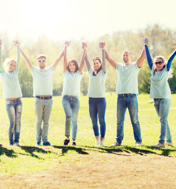 A group of people are holding hands in a field.