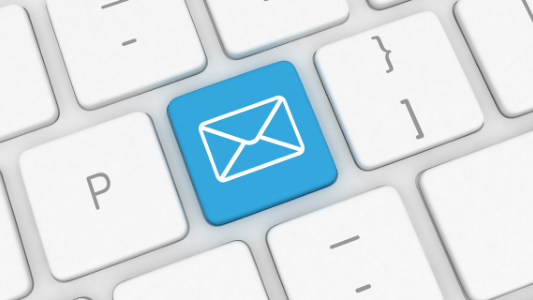 A keyboard with a blue button with an envelope on it.