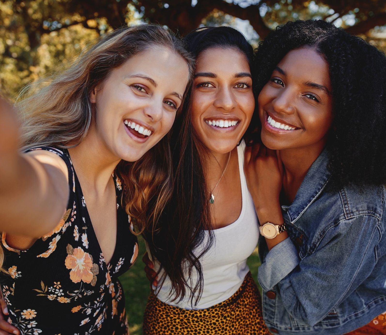 Three women are taking a selfie together and smiling for the camera