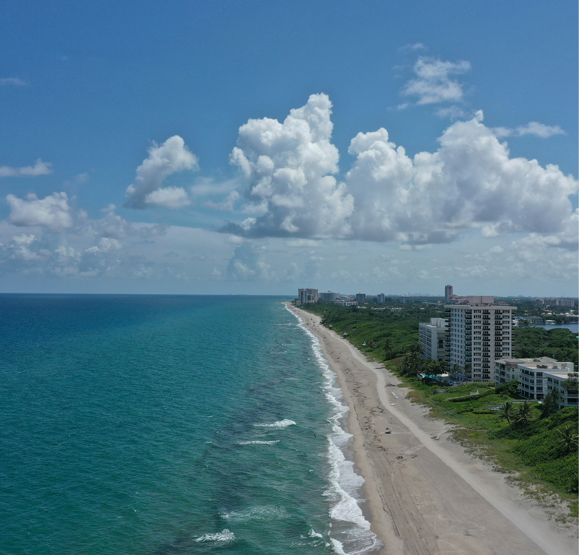 An aerial view of a beach with buildings in the distance