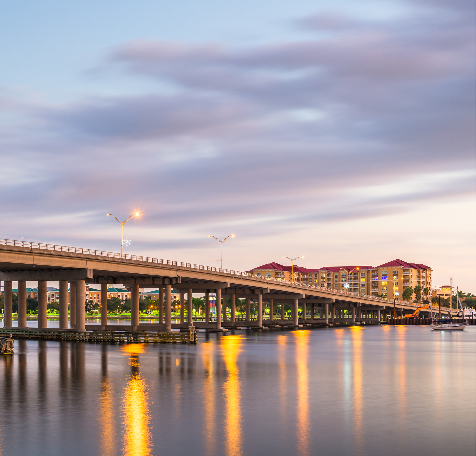 A bridge over a body of water with buildings in the background
