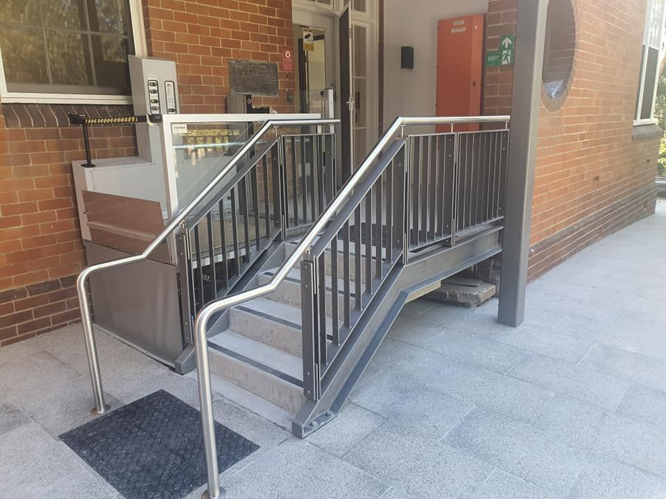 A Set of Stairs Leading Up to a Brick Building — Proweld Steel Fabrication In Southern Highlands, NSW