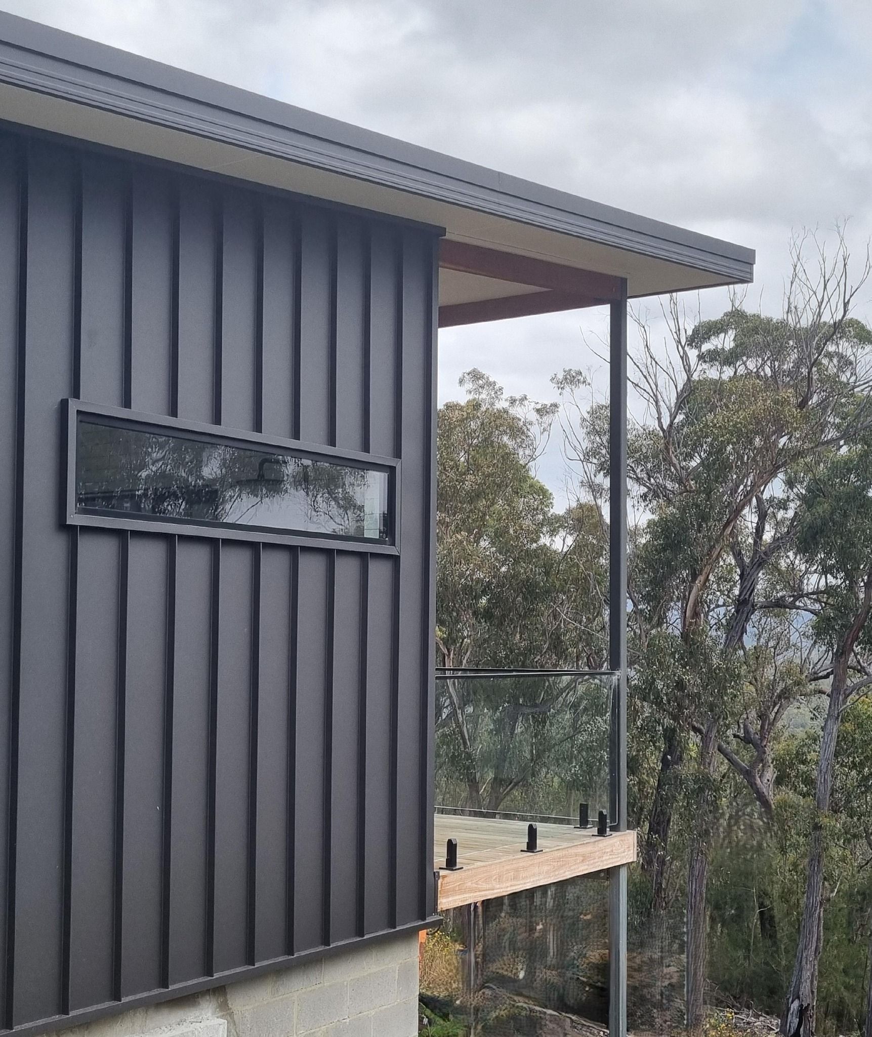 A white house with a black roof and a white gutter.