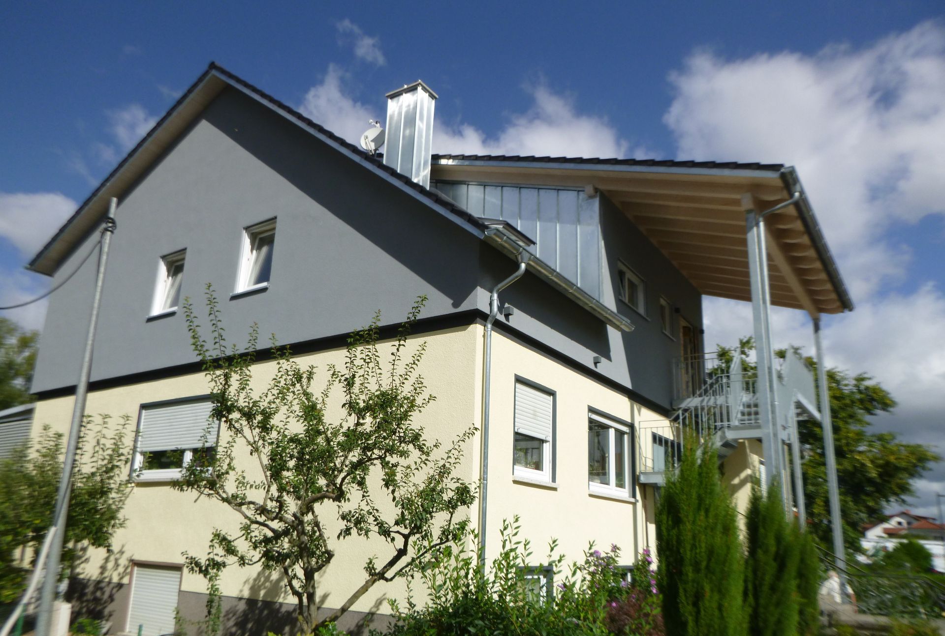 Ein Mehrfamilienhaus mit aussenliegender Treppe.