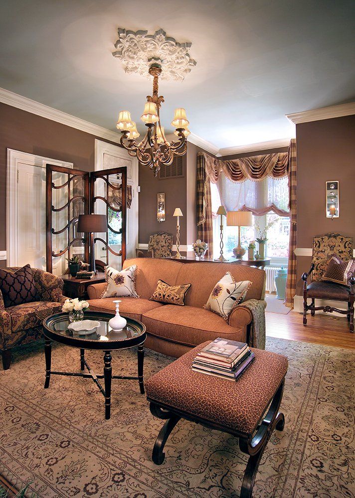 A living room with brown furniture and a chandelier