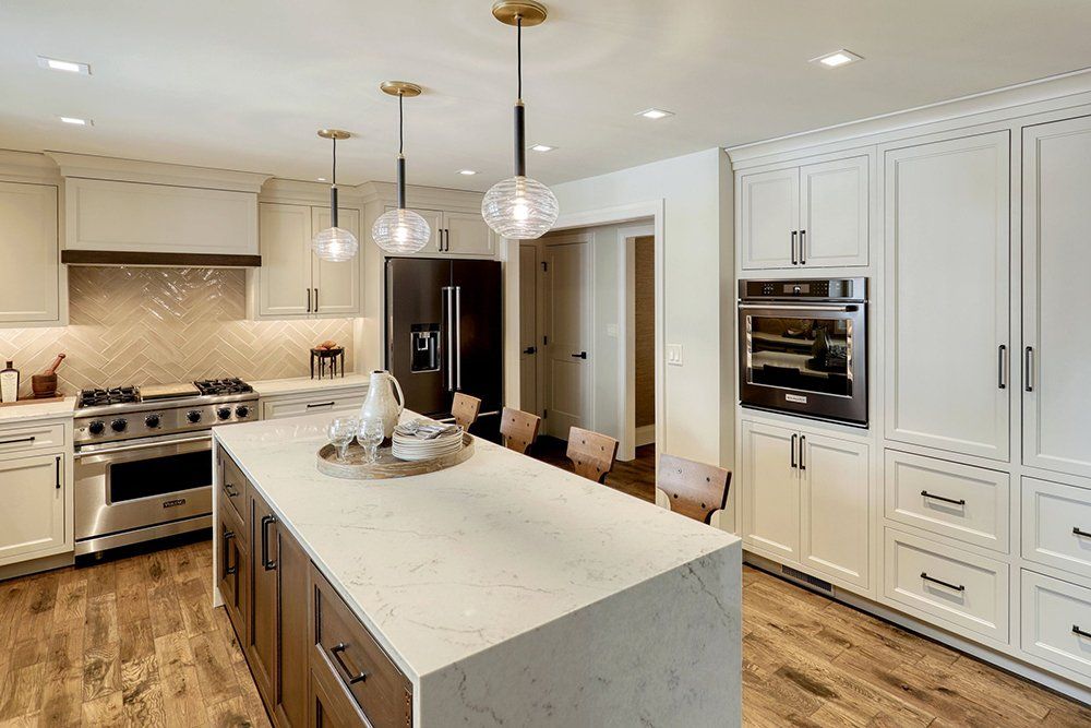A kitchen with white cabinets and a large island in the middle
