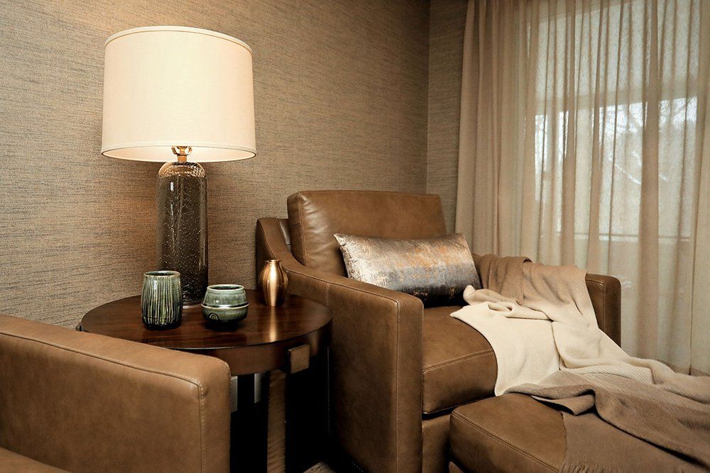 A living room with two chairs and a lamp