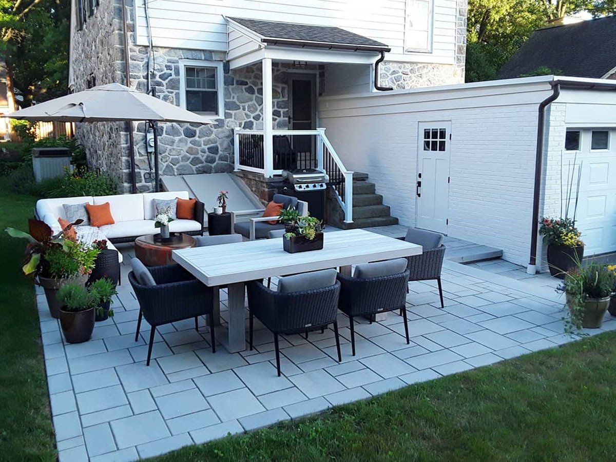 A patio with a table and chairs in front of a house