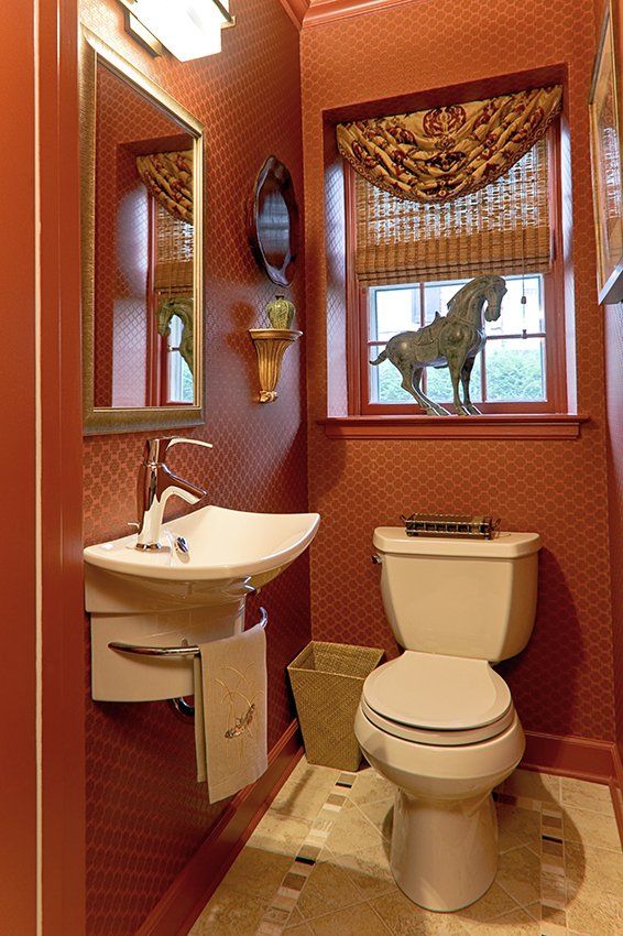 A bathroom with a toilet a sink and a mirror