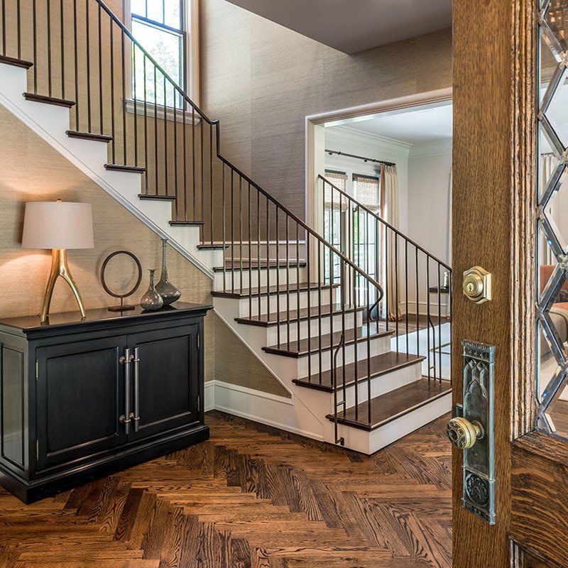A staircase with a black cabinet underneath it