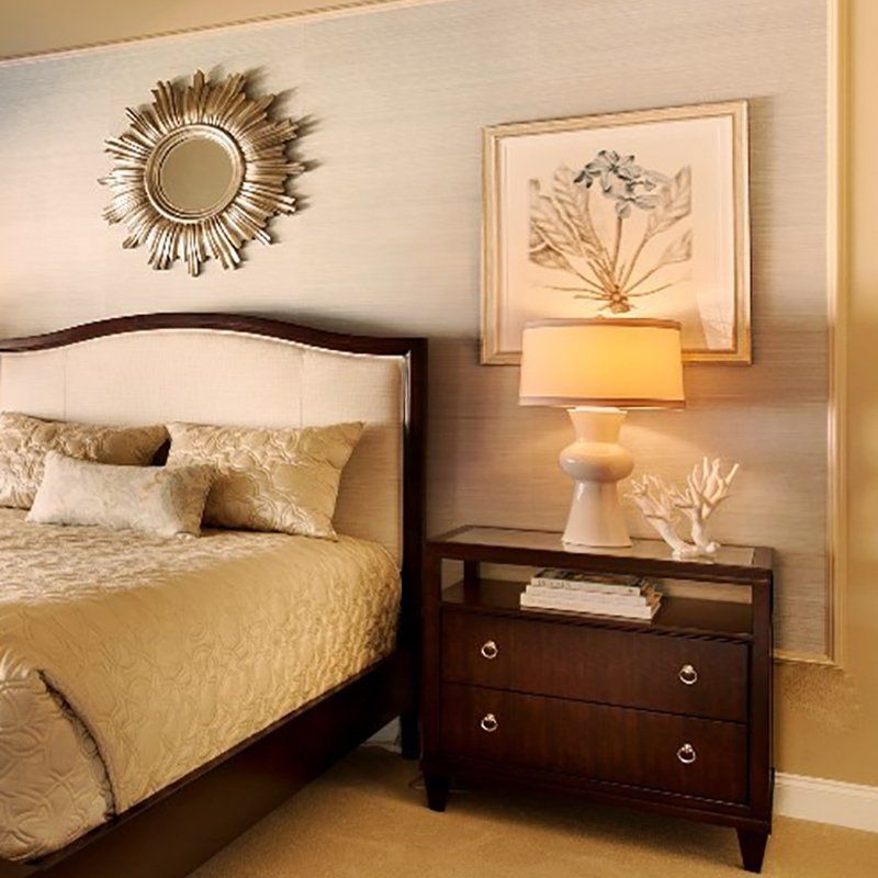 A bedroom with a bed a nightstand and a lamp