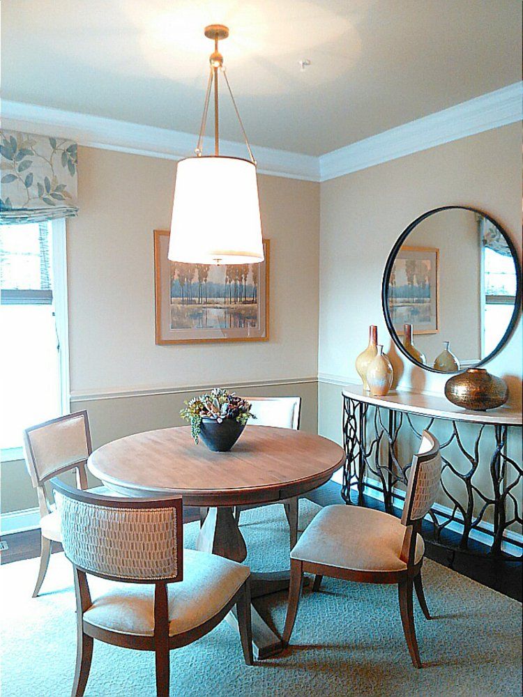 A dining room with a round table and chairs