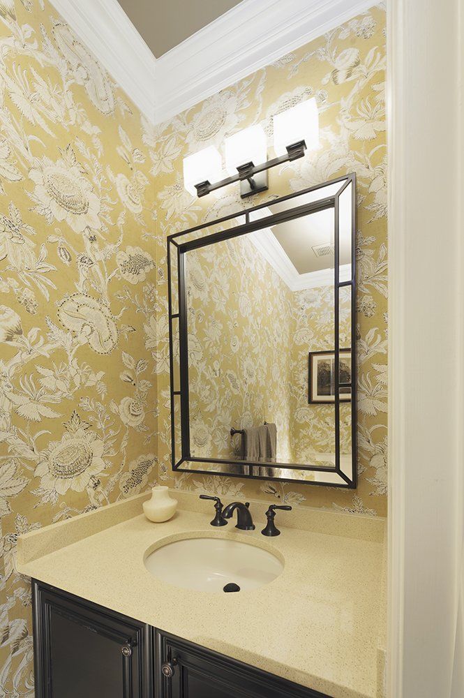 A bathroom with a sink and a mirror with the letter m on it