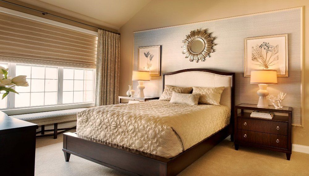 A bedroom with a large bed and a mirror on the wall