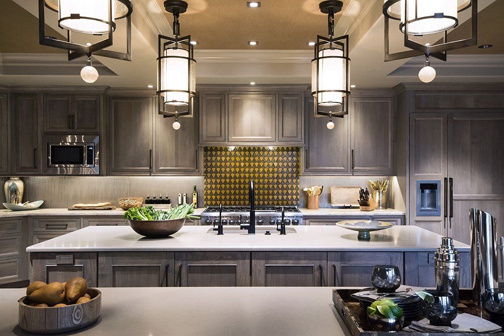 A kitchen with gray cabinets and white counter tops