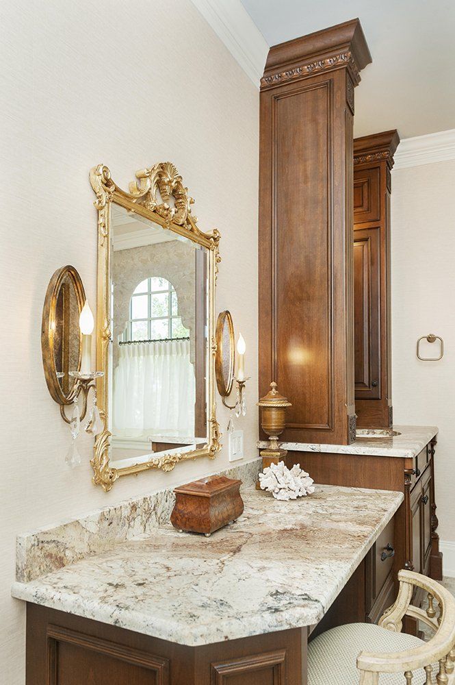 A bathroom with a marble counter top and a mirror