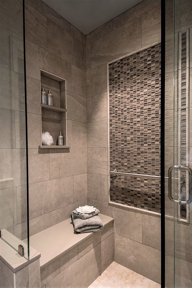 A bathroom with a walk in shower and a bench