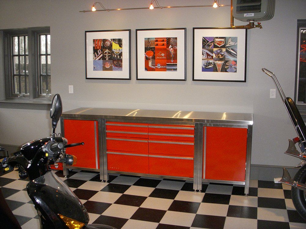 A motorcycle is parked in a garage with a checkered floor