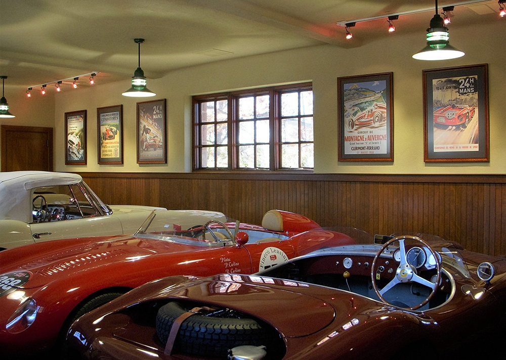 A red sports car is parked next to a white car