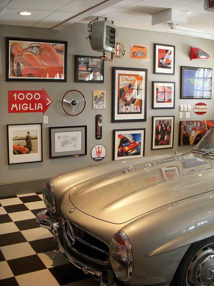 A car is parked in a garage with a 1000 miglia sign on the wall