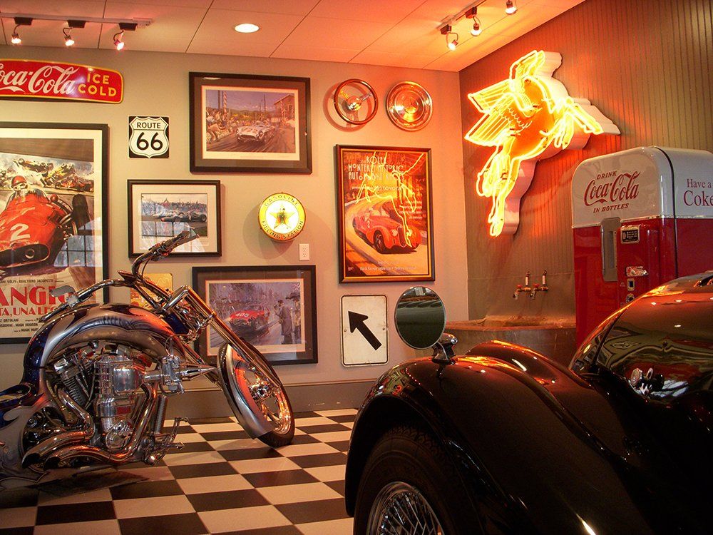 A coca cola sign hangs above a motorcycle in a garage