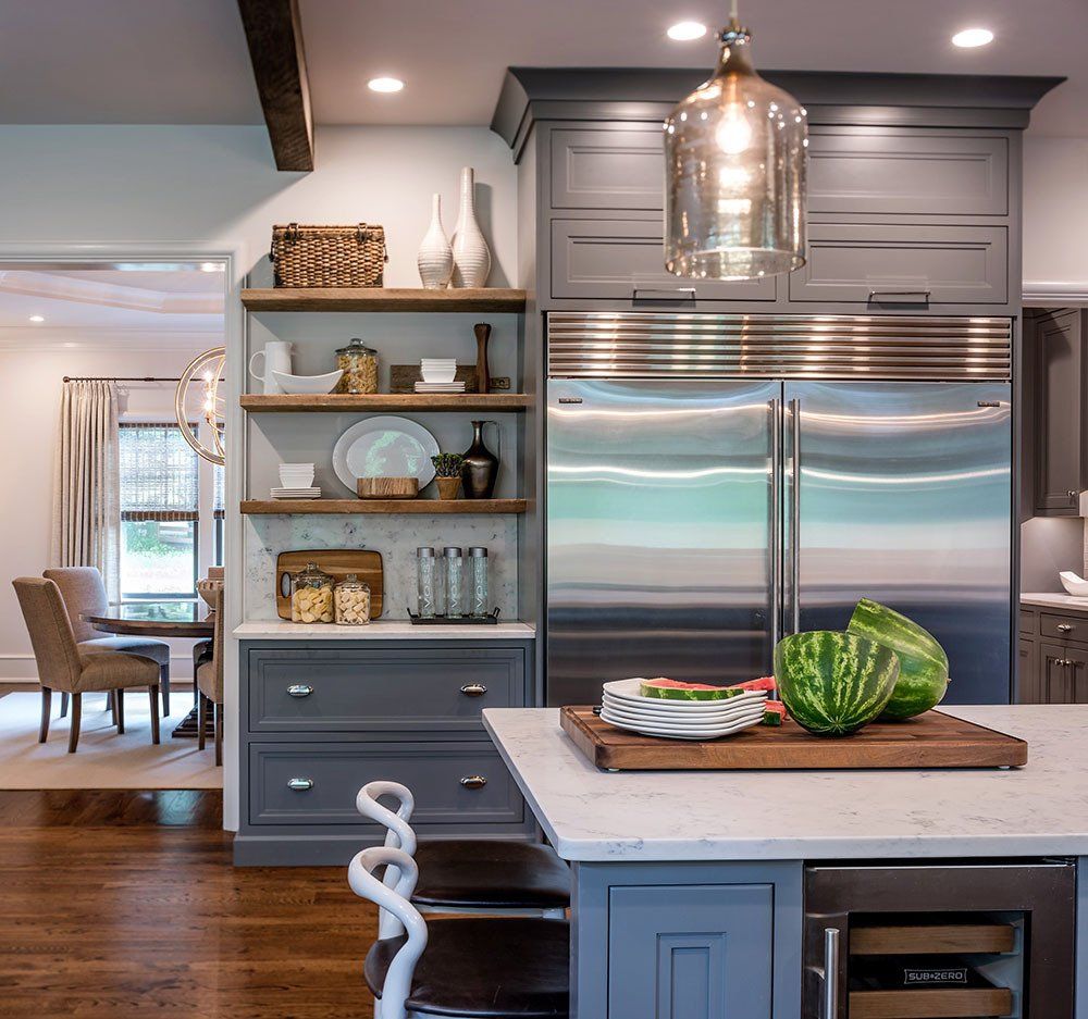 A kitchen with a watermelon on a cutting board
