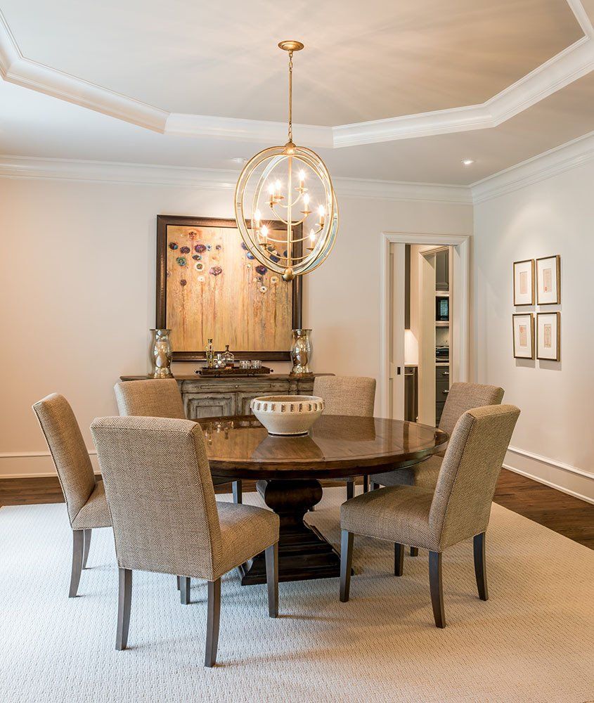 A dining room with a round table and chairs