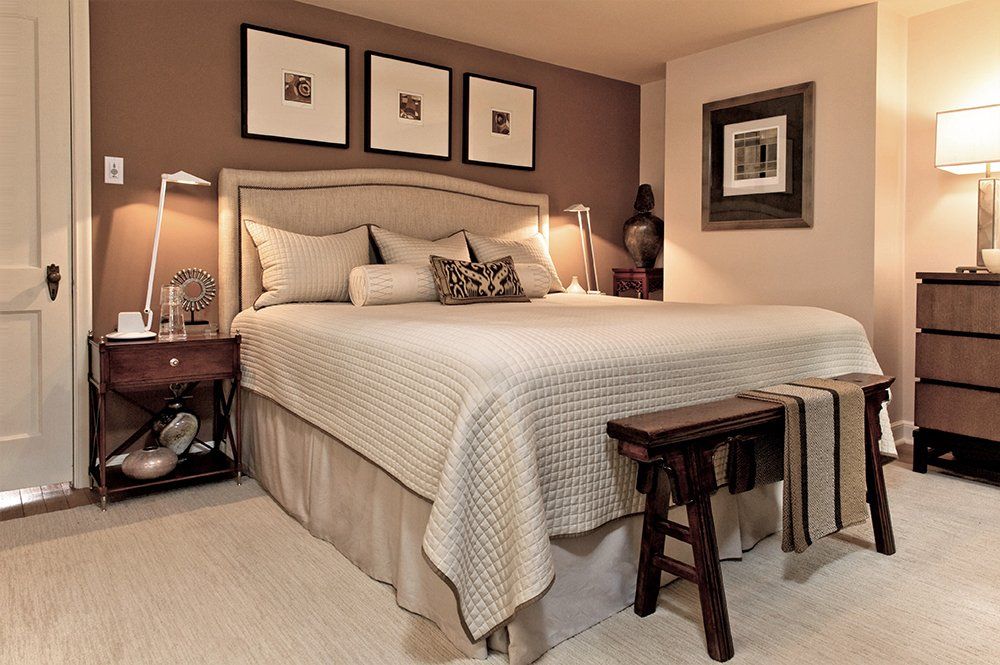 A bedroom with brown walls and a large bed