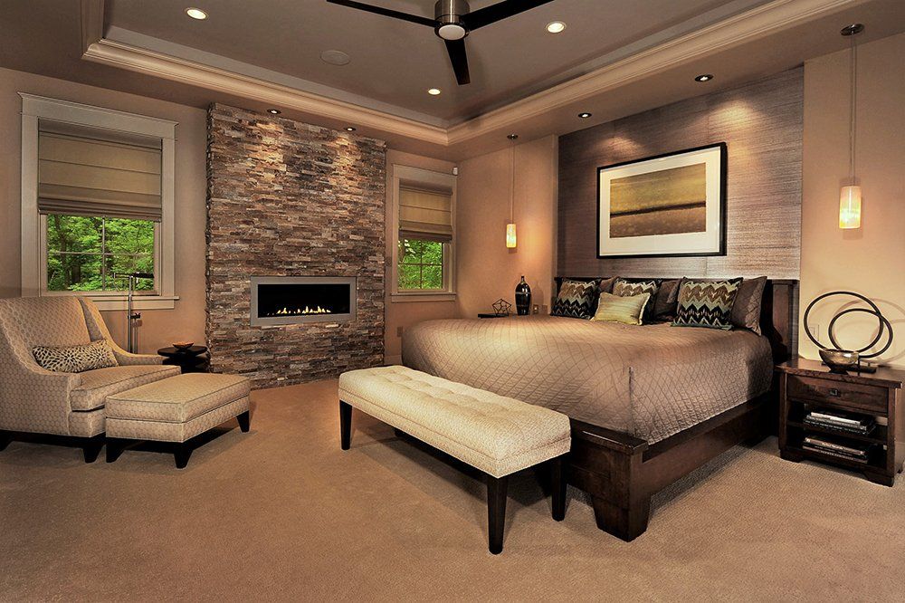 A bedroom with a large bed and a fireplace