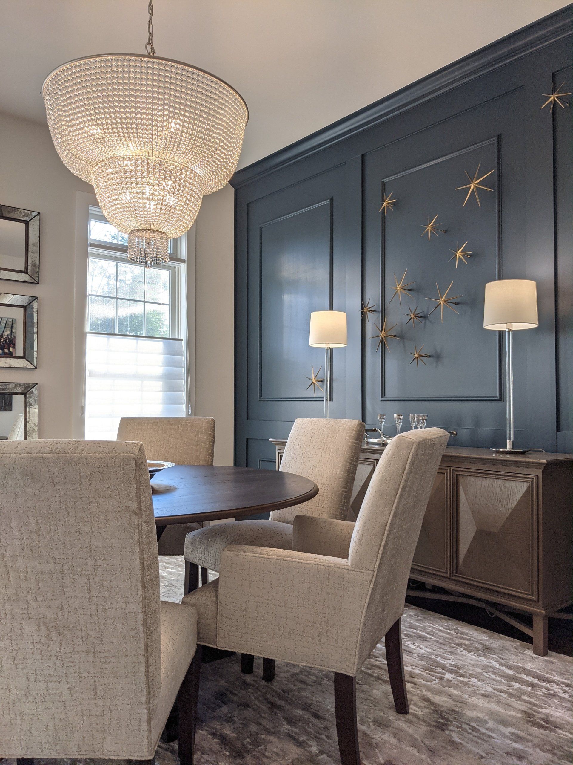 A dining room with a table and chairs and a chandelier