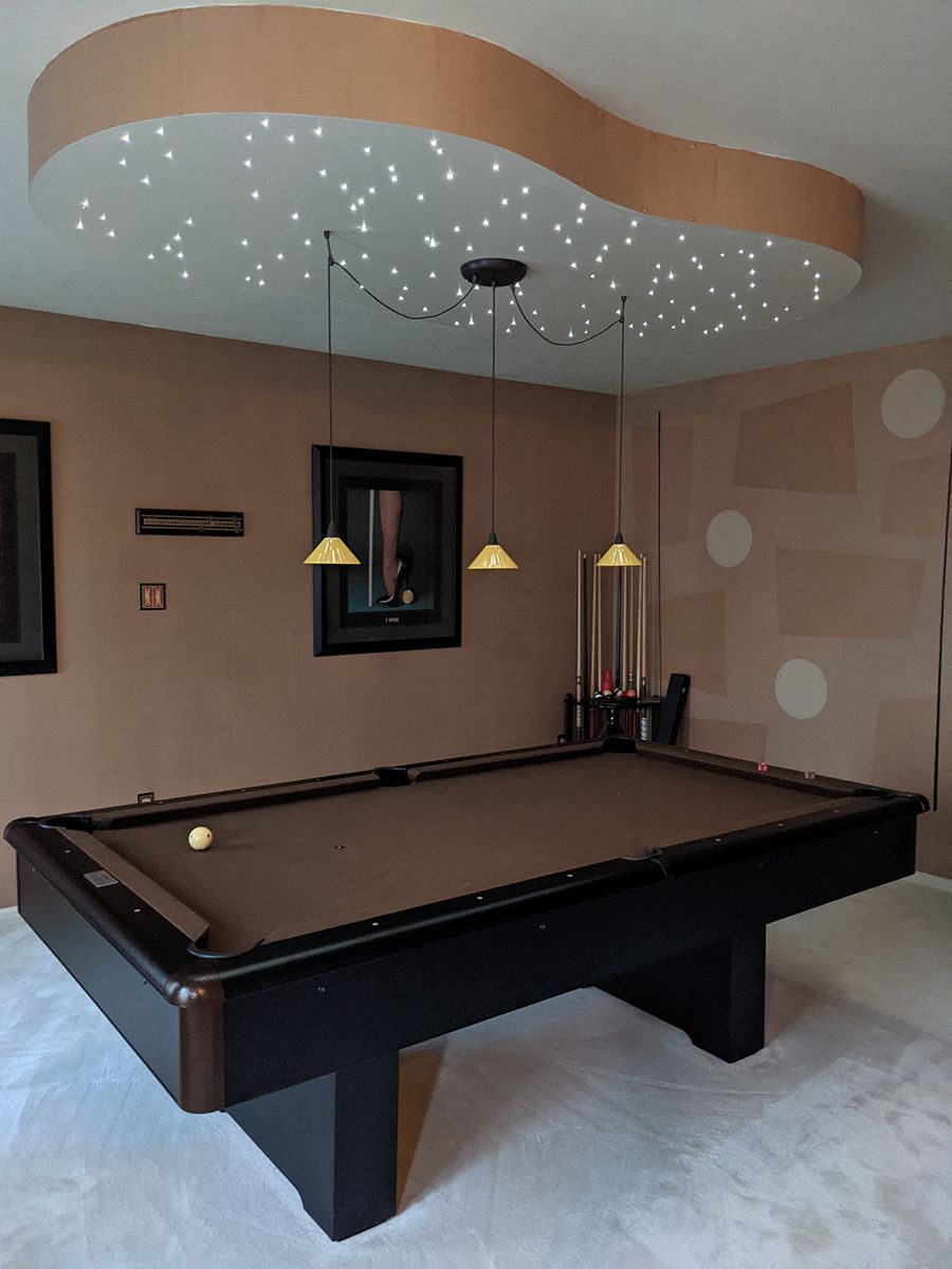 A pool table in a room with a starry ceiling