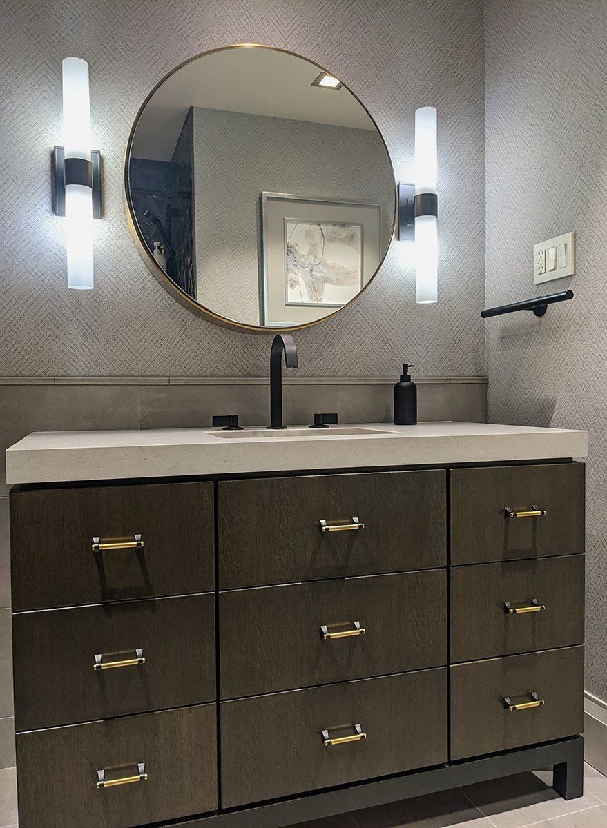 A bathroom with two sinks and a round mirror