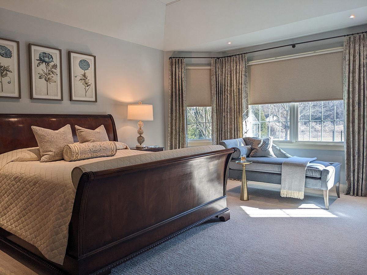 A bedroom with a sleigh bed and a chair