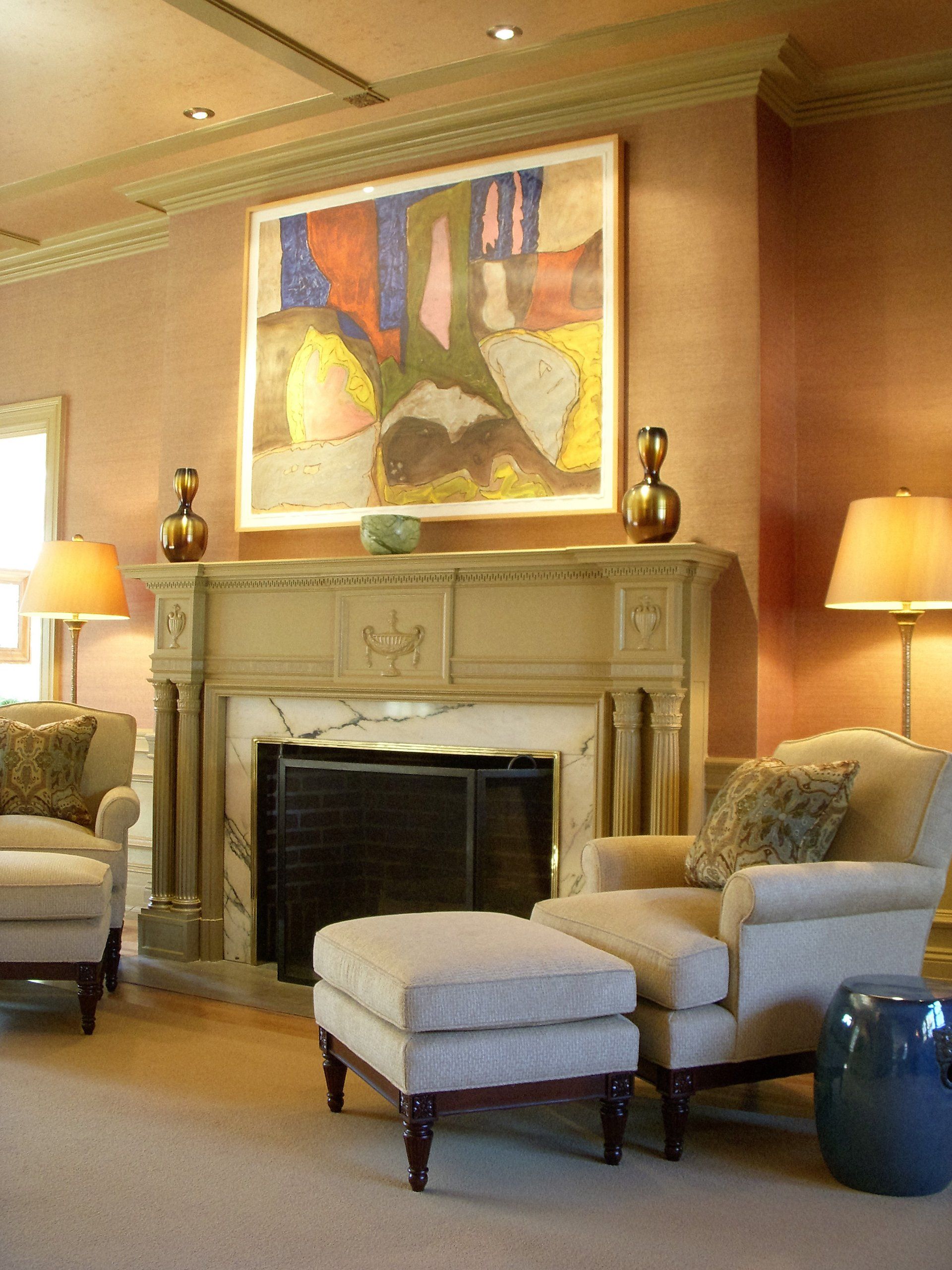 A living room with a fireplace chairs and ottomans