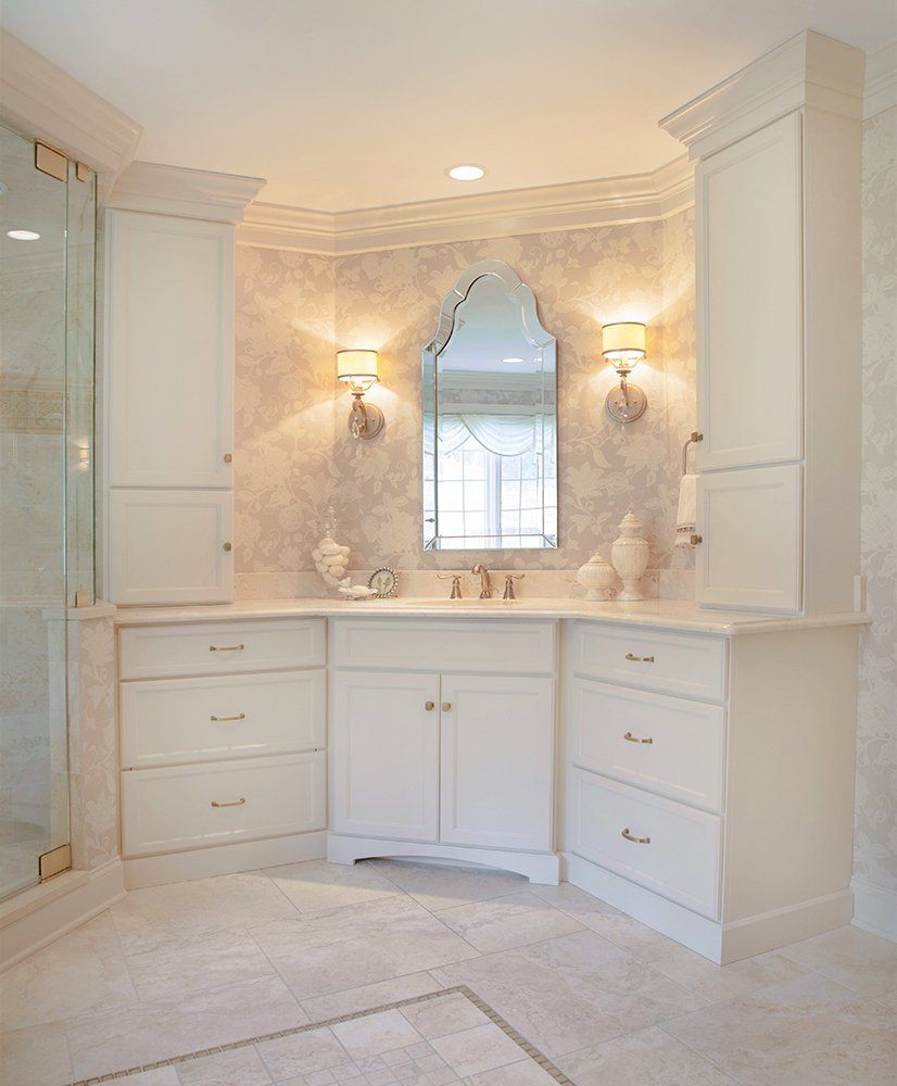 A bathroom with white cabinets and a large mirror