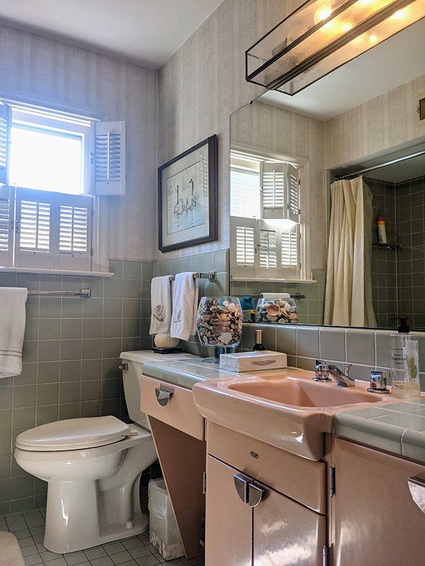 A bathroom with a toilet a sink and a window