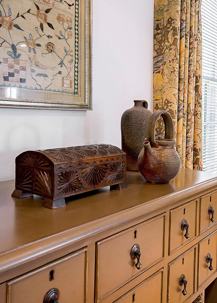 A dresser with drawers and a picture on the wall
