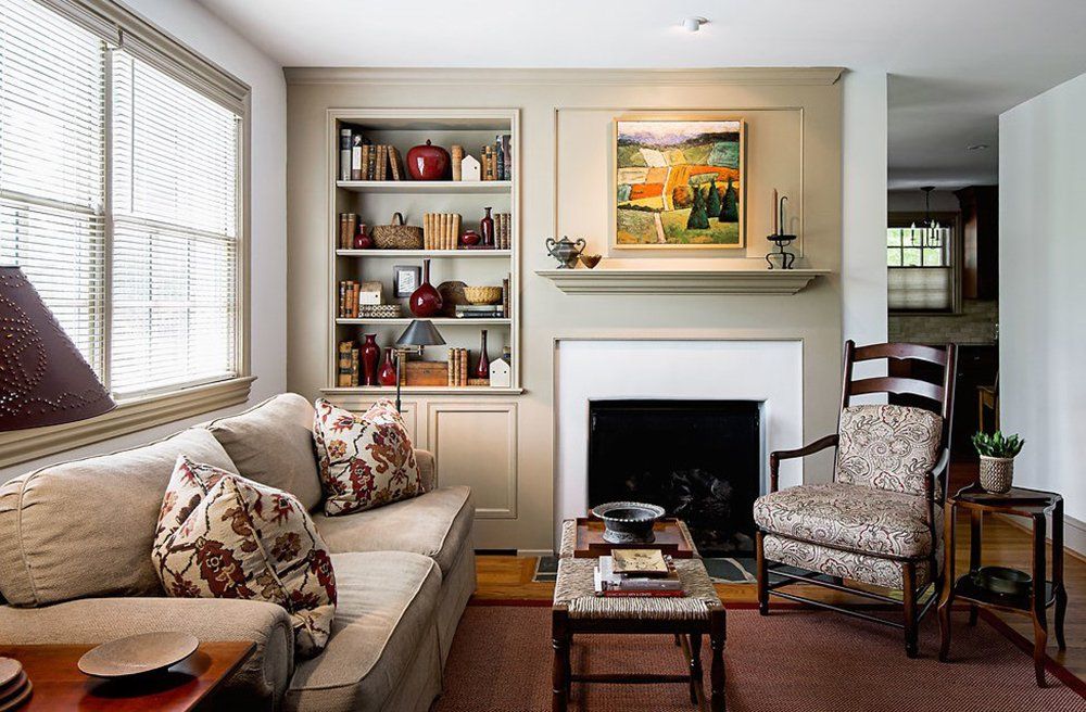 A living room with a fireplace and a painting on the wall