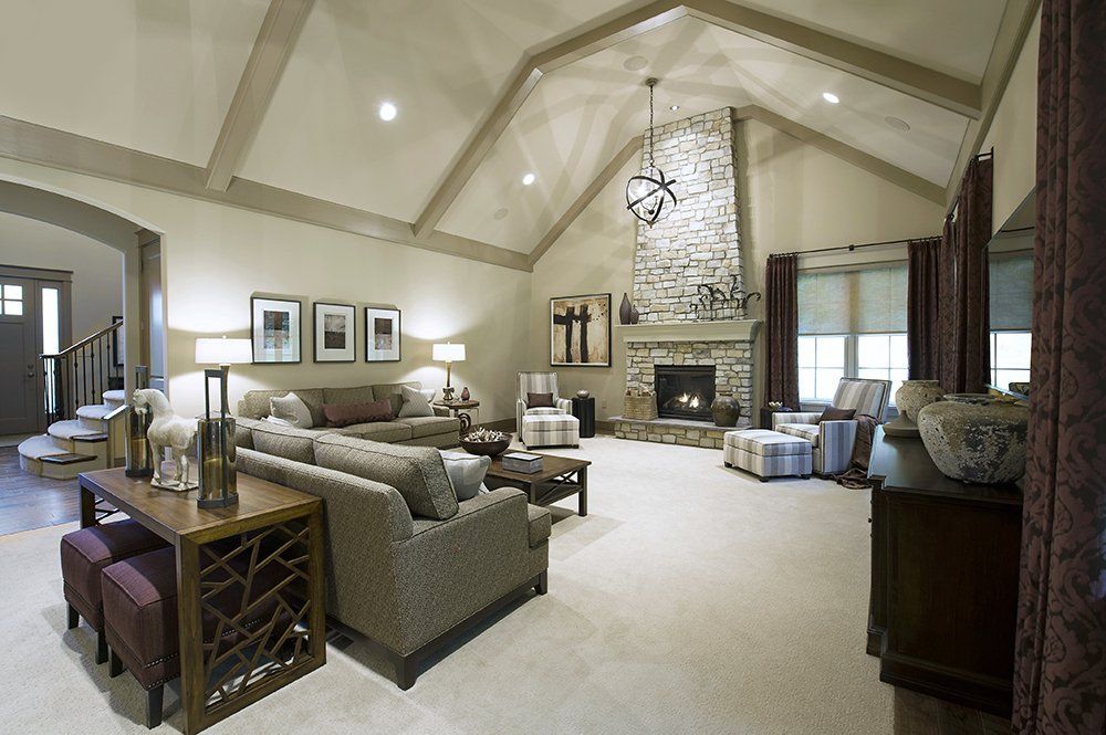 A living room with a vaulted ceiling and a fireplace