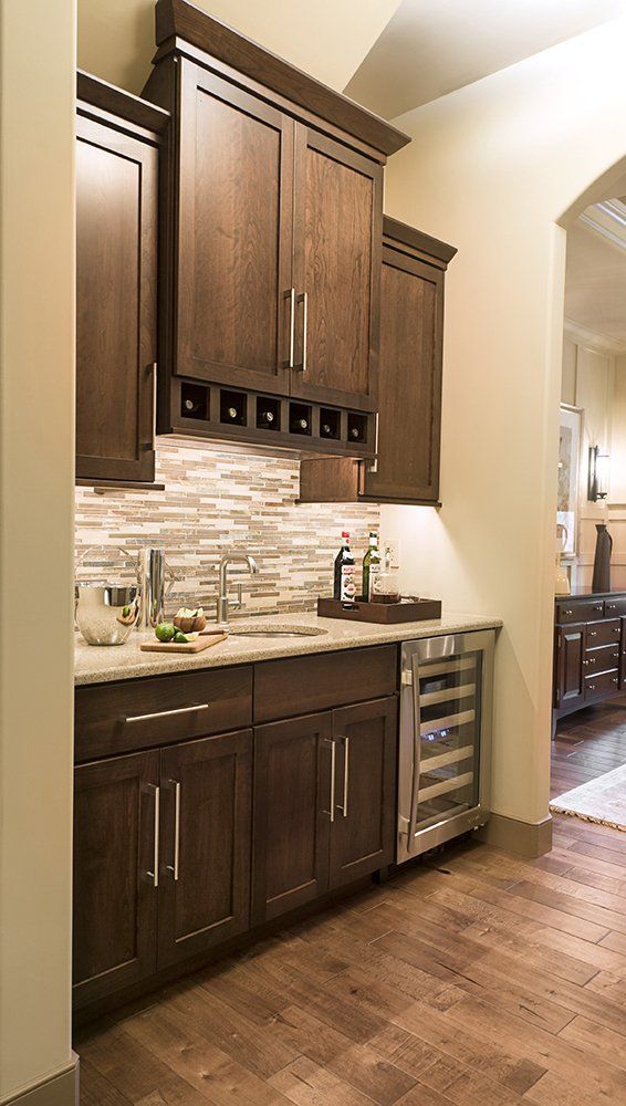 A kitchen with wooden cabinets and a wine cooler