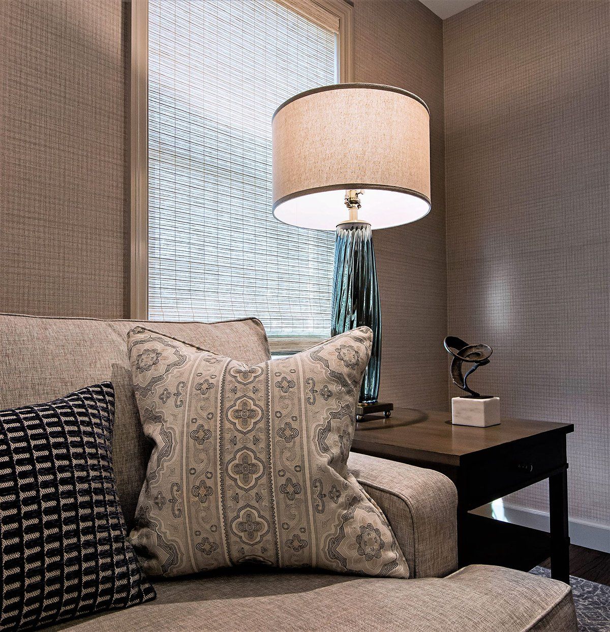 A lamp sits on a table next to a couch